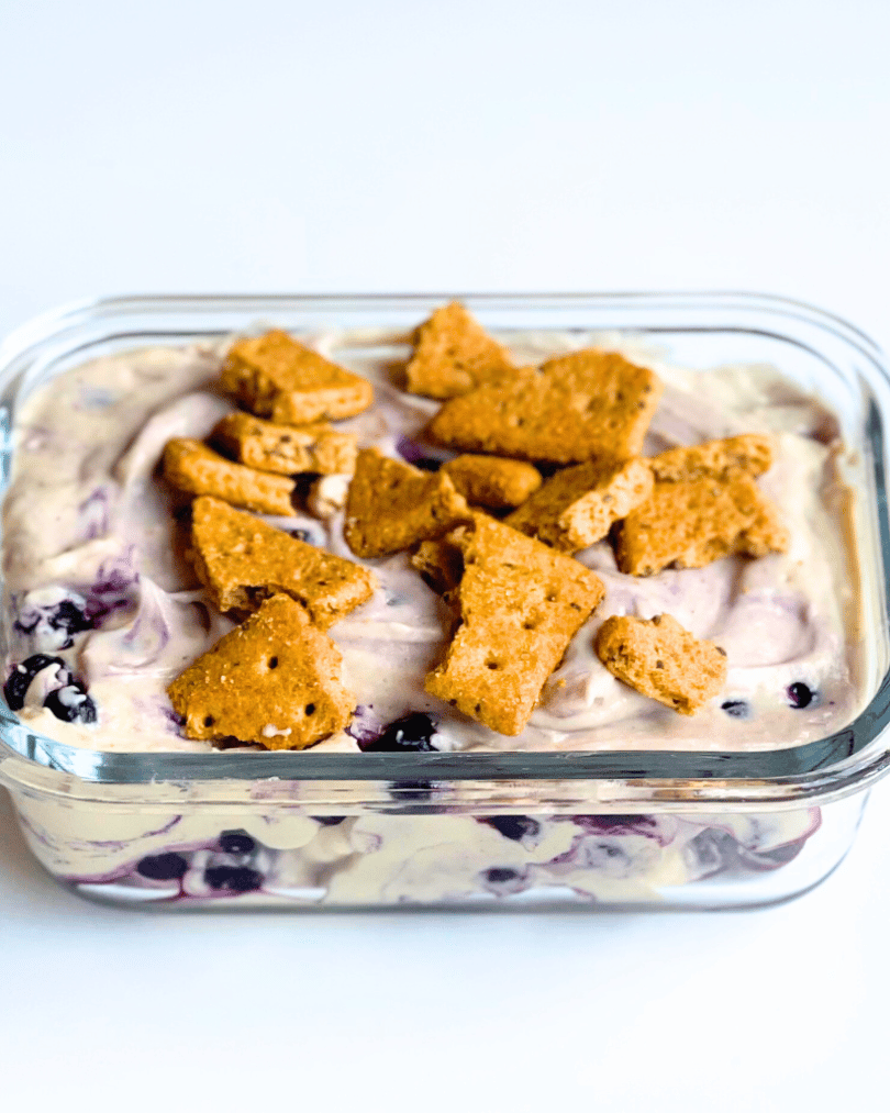vegan blueberry cheesecake protein yogurt bowl in a glass container