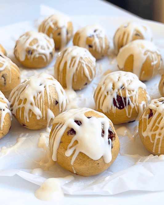 cranberry bliss bar balls on a white parchment paper on a white counter