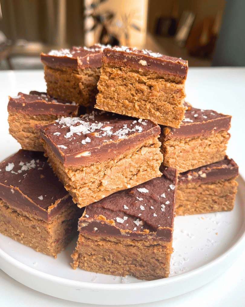 no bake oat fudge bars on a white plate with coarse sea salt on top