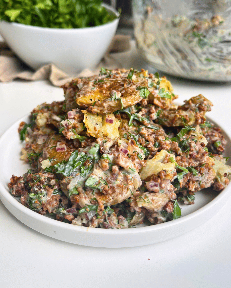 vegan smashed potato salad on a white plate