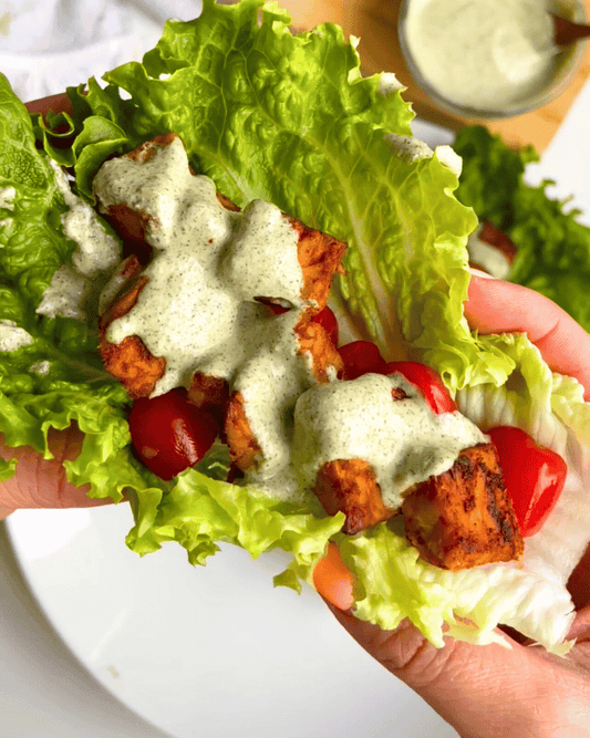 tempeh bacon lettuce wrap being held by two hands up close