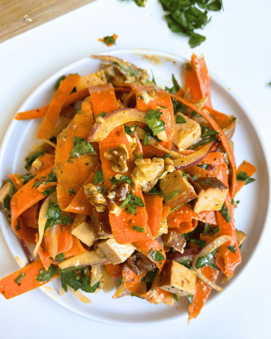 Raw Carrot Salad on a white plate with a white background.