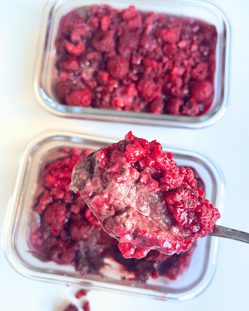 chocolate chia seed pudding in glass jars with a spoon digging a big spoonful out of one