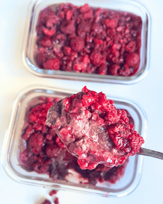 chocolate chia seed pudding in glass jars with a spoon digging a big spoonful out of one