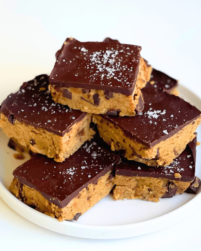 cookie dough protein bars piled on a white plate
