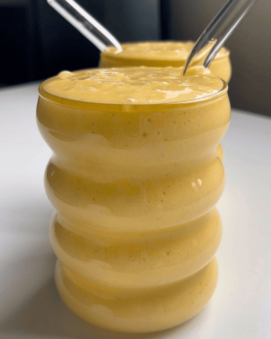 mango refresher protein and electrolyte drink in a glass bubble cup with glass straws