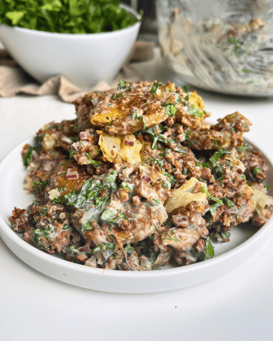 vegan smashed potato salad on a white plate