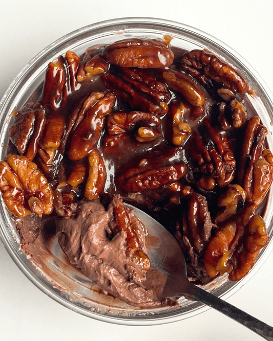 chocolate pecan protein pudding with a spoon digging into it