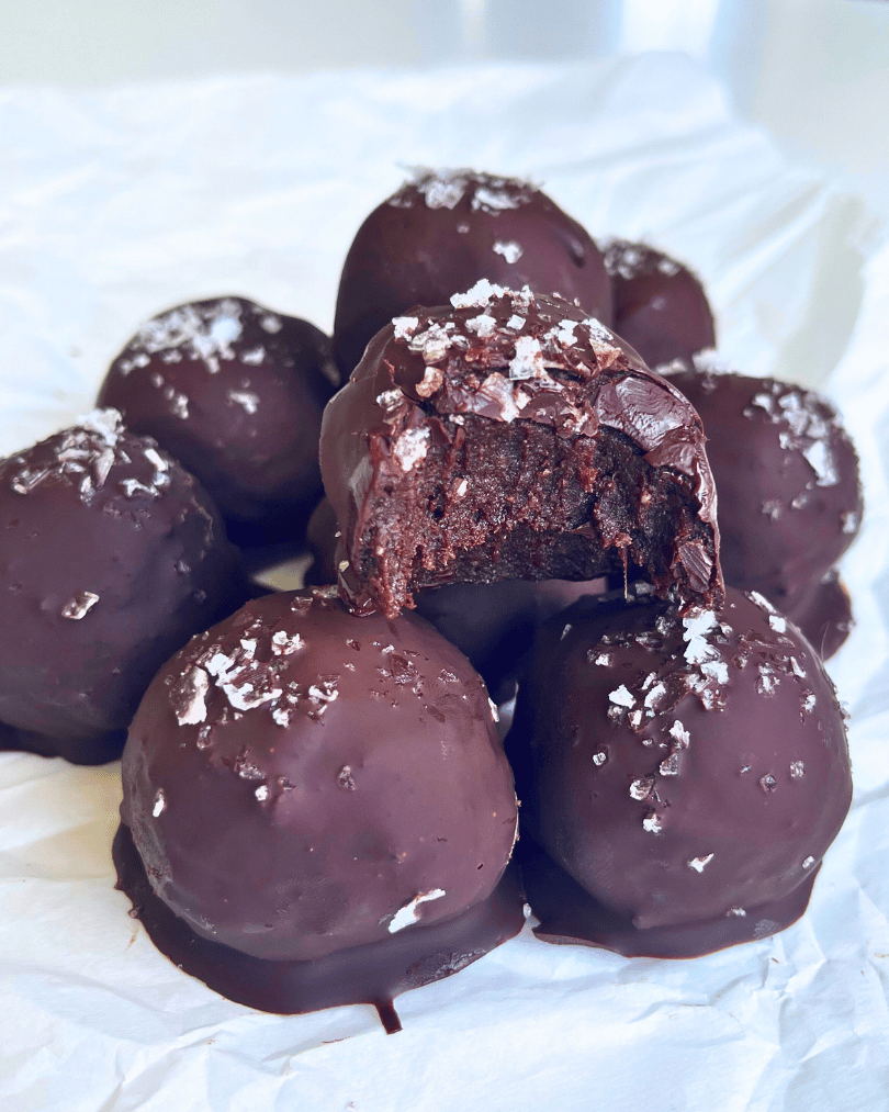 Viral brownie balls on a white parchment paper with a bite missing 