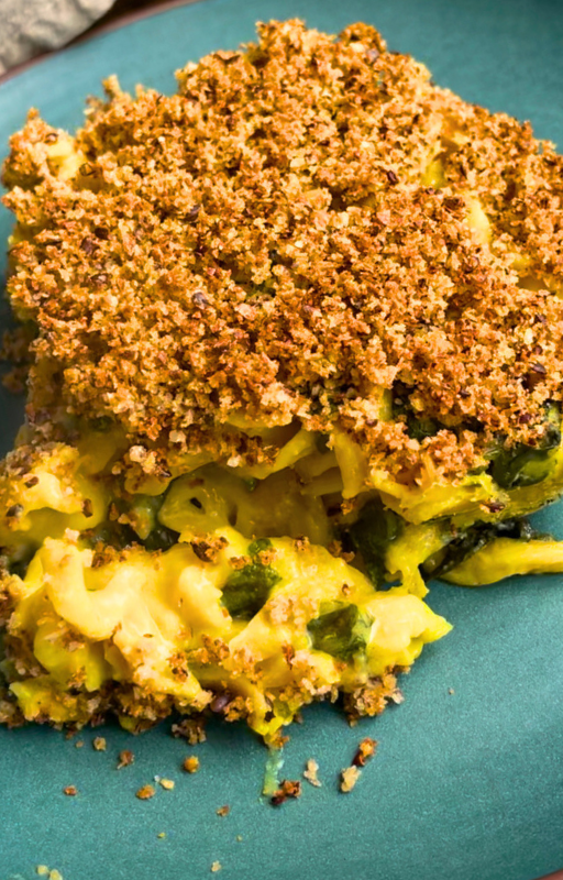 A slice of vegan baked mac and cheese on a green plate