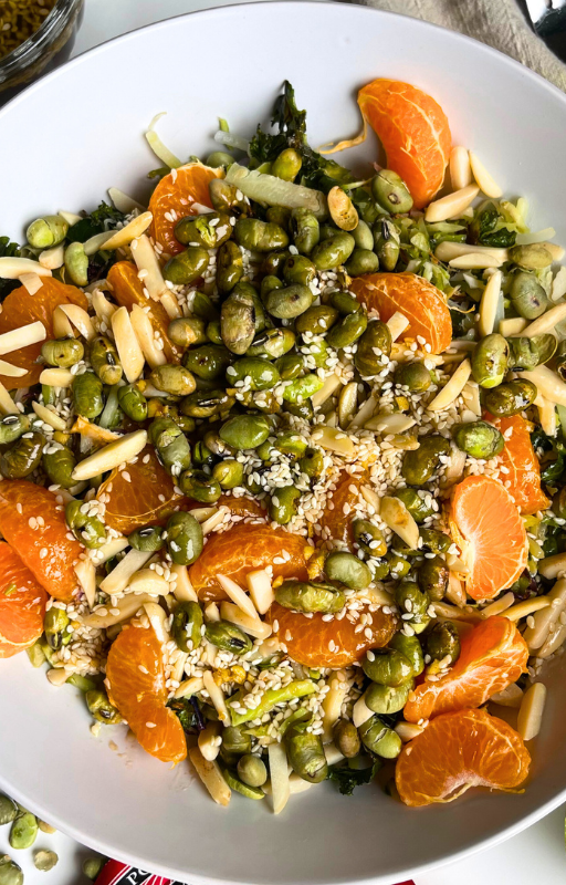 Vegan edamame salad with mandarin on a white plate